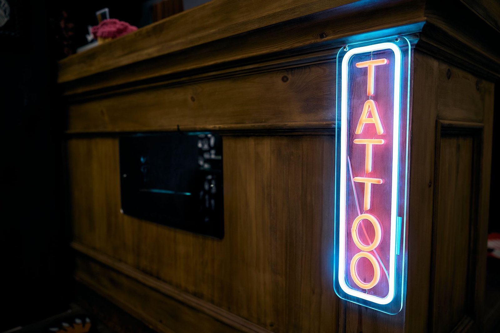 Cartel neon de 'Veneno Tattoo The Gallery' en un estudio de tatuajes